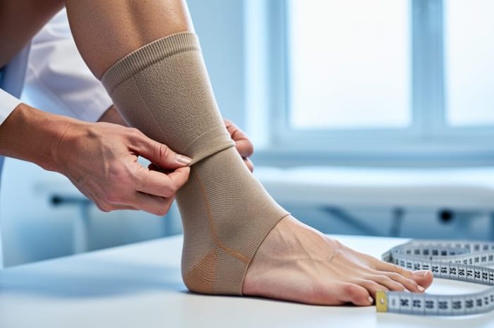Clinician’s hands adjusting a graduated compression sock on a patient’s calf in a medical exam room.